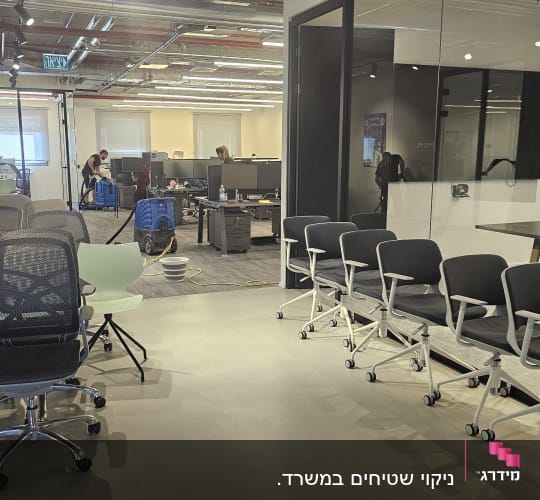 עובדים מנקים משרד עם כיסאות וכלי ניקוי